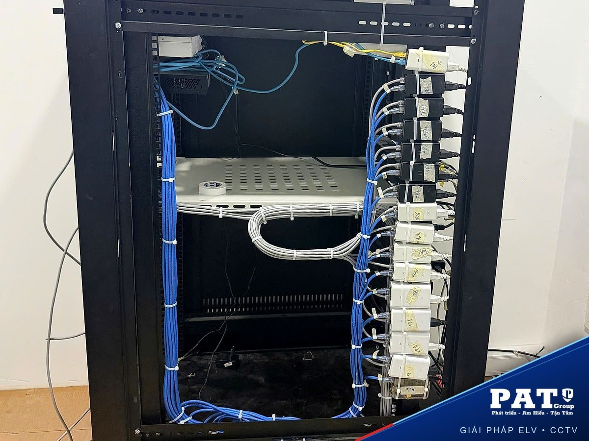 Dãy bộ cấp nguồn PoE cho access point dán nhãn AP và các bó cáp mạng được cố định gọn trong tủ rack